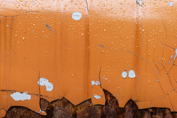 Close up on wet surface of orange grunge and rusty metal.