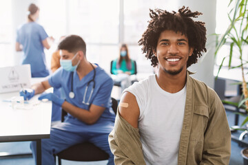 Happy Black Man Showing Hand With Patch After Vaccine - obrazy, fototapety, plakaty
