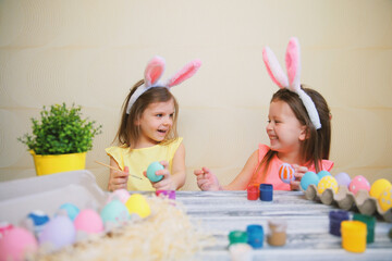 Children in fun paint and decorate Easter eggs while wear bunny ears. Preparing for Easter