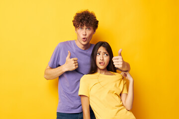Fototapeta premium cute young couple in colorful t-shirts posing friendship fun isolated background unaltered