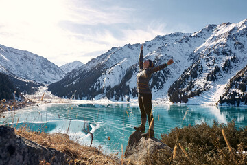 A woman walking near a frozen mountain lake 