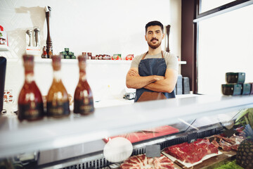 Portrait of confident young salesman standing in butcher's shop