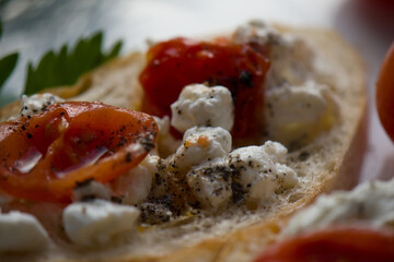 Bruschetta with tomatoes, herbs, cottage cheese and ground pepper. Close-up.