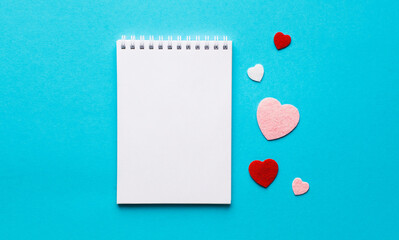 Valentine's day composition with notebook list and hearts on blue background. Wedding, birthday, woman's and mother day concept. Flat lay, top view, copy space, place for text, empty, mock up, banner