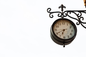 Old antique street clock made of bronze on a white background