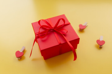 Decorative red gift box on the yellow background. Top view