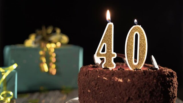 Birthday candle number forty on a sweet cake on the table, 40th birthday. Fire from the lighter, blow out the holiday candle.