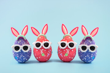 Colorful Easter egg with bunny ears and sunglasses on a blue background. Sale banner, mockup template. copy space