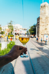 A glass of white wine against the background of the streets of Antalya in Turkey. Summer, travel, lifestyle, relaxation, and enjoyment concept.