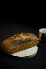 bread on a wooden plate on a black background