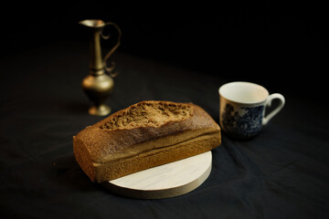 bread on a wooden plate on a black background
