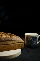 bread on a wooden plate on a black background
