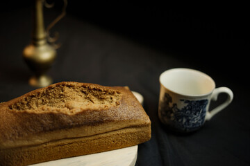 bread on a wooden plate on a black background