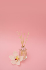 Aroma diffuser and exotic flower over pink background
