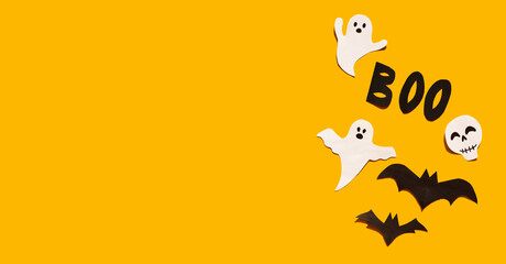 Halloween set decorations with ghost, bat, skeleton and word BOO on yellow background. Holiday party, minimal greeting card, spooky concept. flat lay, copy space, top view, place for text