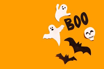 Halloween set decorations with ghost, bat, skeleton and word BOO on orange background. Holiday party, minimal greeting card, spooky concept. flat lay, copy space, top view, place for text