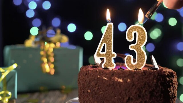 Number forty-three birthday candle on a sweet cake on the table, 43rd birthday. Fire from the lighter, blow out the holiday candle.