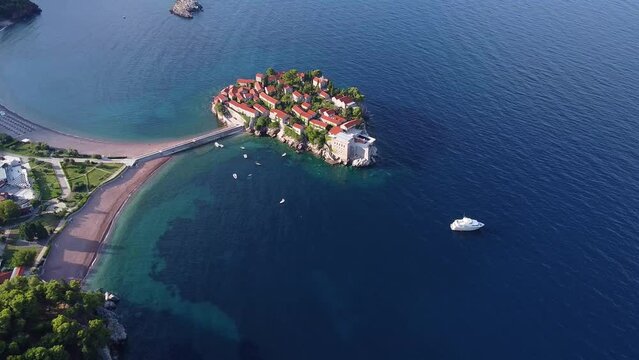 Aerial view of sea spaces with coastal part and small island. Perfect place for spending vacations there. Drone shot of Sveti Stefan (Saint Stephen) island in Montenegro.