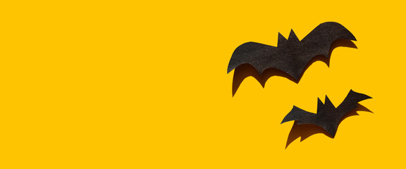 Halloween decorations with two bats on yellow background. Holiday party, minimal greeting card, spooky concept. flat lay, copy space, top view, place for text