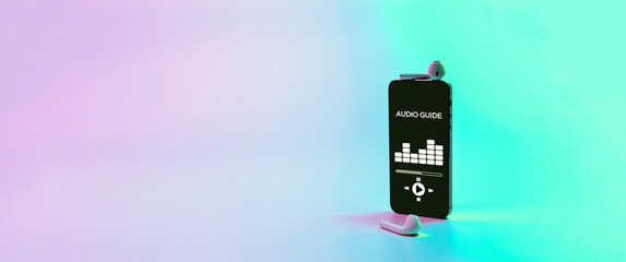 Audio guide online app on digital mobile smartphone screen with music headphones on neon background. Devices for listening audioguide to excursions.