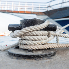 yacht is on the pier. The white rope is tied to the bollard. Anchorage for the boat. Summer...