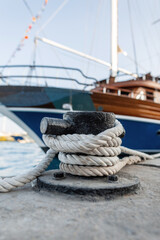 luxurious yacht is moored in port. Sea ship is tied with a white rope to the metal bollard on the...