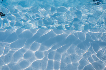 Beautiful colored blue abstract water texture with waves and light reflection. Swimming pool, top view