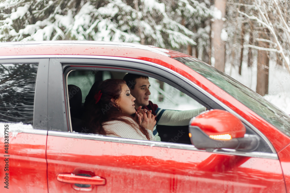 Wall mural Couple . Love. Emotions. Couple in love in the winter forest. Couple in red car. Vacation trip