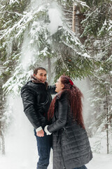 Couple . Love. Valentine's day. Emotions. Man and woman playing in the snow. Couple in love in the winter forest