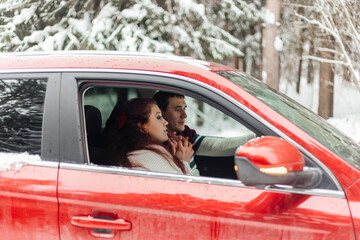 Couple . Love. Emotions. Couple in love in the winter forest. Couple in red car. Vacation trip