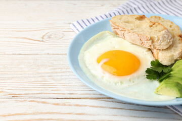 Plate of tasty breakfast on white wooden background