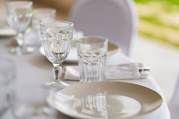 serving of the festive table. an empty white plate and glasses on the table. 