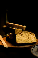 slices of bread on a wooden plate on a black background