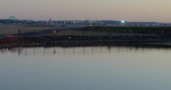 Commercial Jet Taking Off In Evening With Reflections On Water At Washington D.C.&rsquo;s DCA Airport