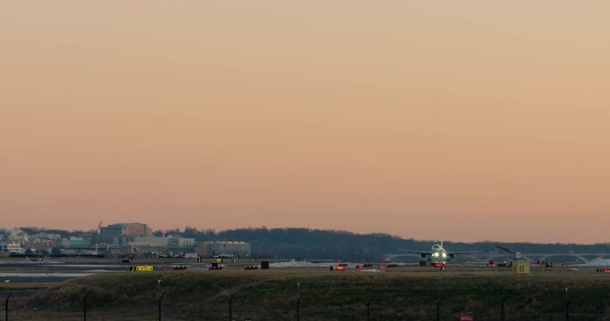 Camera Following Plane Taking Off After Sunset Framed By Dramatic Orange Sky, Washington D.C.