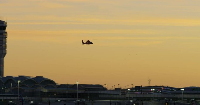 Helicopter Passing Air Traffic Control Tower At Sunset In Silhouette, Washington D.C.