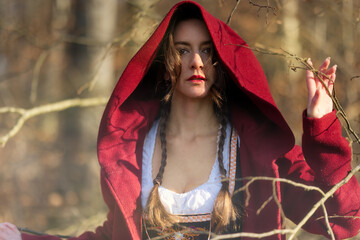 schöne, junge, attraktive Frau mit rotem Mantel läuft durch den Wald, Rotkäppchen, Märchenfigur