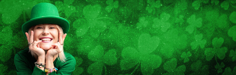 Banner with St. Patrick's Day leprechaun model girl on green magic background with shamrock leaves.