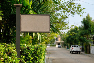 Close-up blank sign on the street and green tree and plant background wallpaper. Display text or advertising.