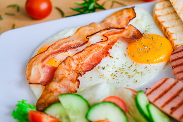 Morning breakfast scrambled eggs with salad, bacon and toast