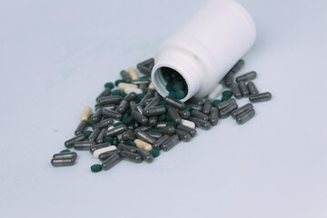 A pile of black medicine or health supplement pills on white background