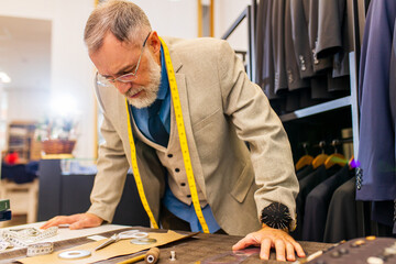 well-dressed bearded mature handsome man working in his atelier studio