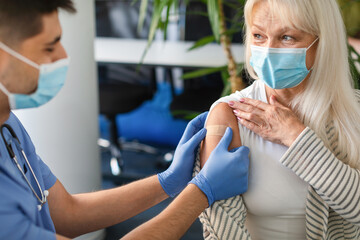 Senior Lady Getting Vaccinated Against Covid, Nurse Applying Adhesive Bandage