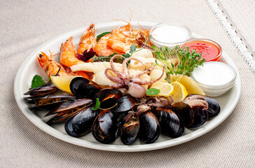 Platter with a variety of fresh seafood and sauces. Octopus, caltmar, mussels, shrimp, scallop.