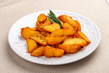 Sliced fried potatoes, Creole-style with spices. On a white plate.