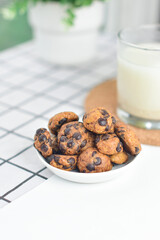 chocolate cookies on a small white plate with minimalistic set