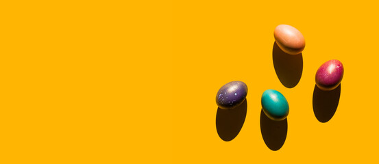 Fototapeta na wymiar Happy Easter holiday concept. Set of handmade colorful eggs isolated on yellow background with shadow. Simple trendy minimal composition, flat lay, top view, copy space, place for text, banner