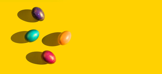 Happy Easter holiday concept. Set of handmade colorful eggs isolated on yellow background with shadow. Simple trendy minimal composition, flat lay, top view, copy space, place for text, banner
