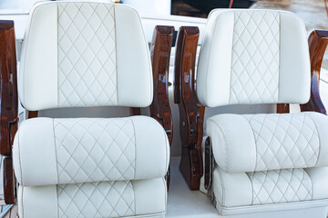 Two white leather armchairs on a luxury motor boat, close-up.