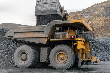 Excavator loads ore into a dump truck.